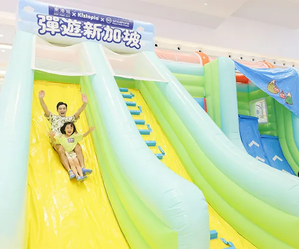 Kids enjoying a large inflatable slide at an event